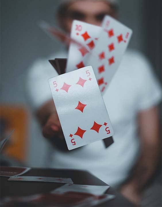 Un jet de cartes contre l'objectif de l'appareil photo du magicien lyon