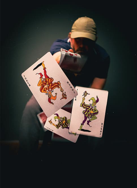 Un élève de l'ecole de magie lyon lance des cartes contre l'objectif de l'appareil photo